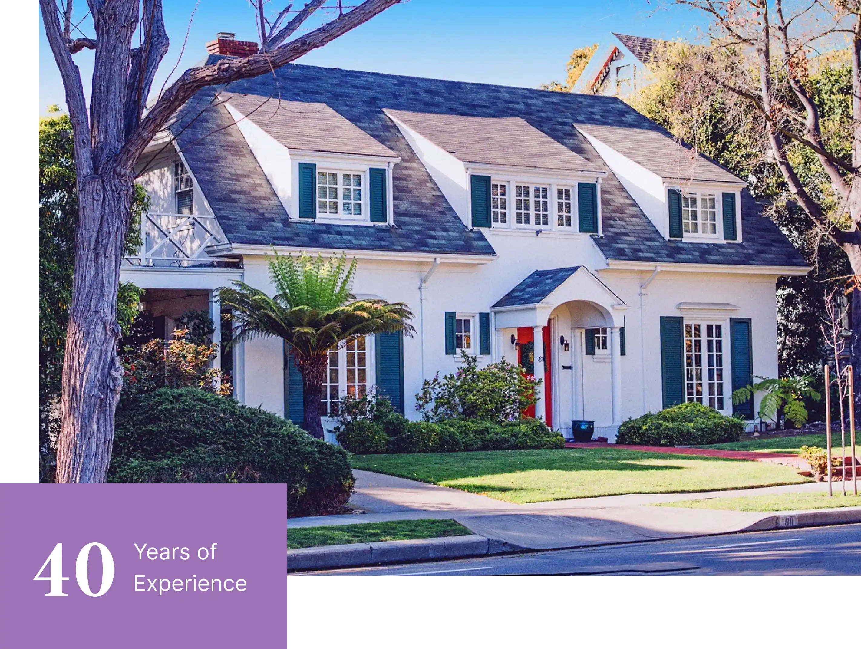 A white two-story house with green shutters and a well-kept lawn. A purple banner at the bottom left reads "40 Years of Experience.