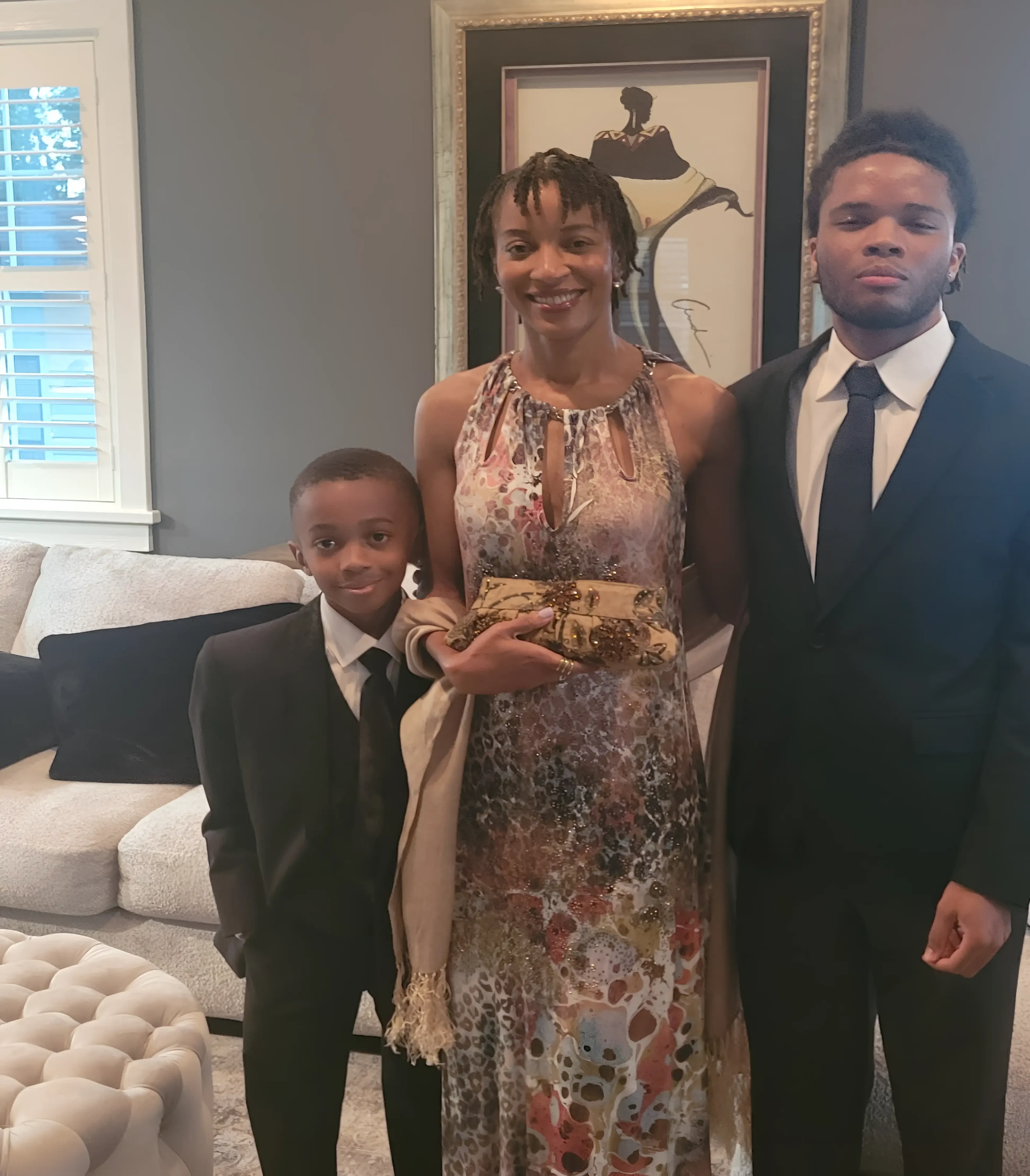 A woman and two boys in suits posing for the camera.